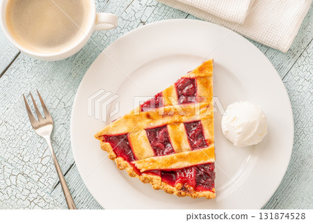 Cherry pie slice with melting ice cream and coffee on white plate 131874528