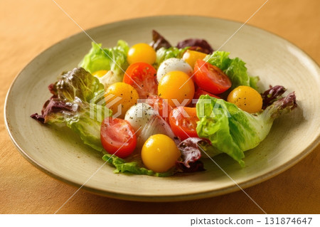 Vibrant salad from fresh lettuce and juicy cherry tomatoes in a ceramic bowl on a beige background. Tomato leafy greens salad with herbs and spices. Healthy food diet cuisine. Fresh nutrition plate. Vibrant salad from fresh lettuce and juicy cherry tomatoes in a ceramic bowl on a beige background. Tomato leafy greens salad with herbs and spices. Healthy food diet cuisine. Fresh nutrition plate. 131874647