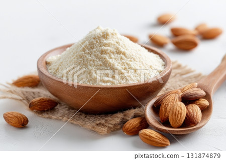 Almond flour. Almond nuts and almond flour in a wooden bowl and spoon. White table background. Grated almonds pile. Gluten-free produce for health. Low Carb Keto, celiac, paleo, and wheat-free diets Almond flour. Almond nuts and almond flour in a wooden bowl and spoon. White table background. Grated almonds pile. Gluten-free produce for health. Low Carb Keto, celiac, paleo, and wheat-free diets 131874879