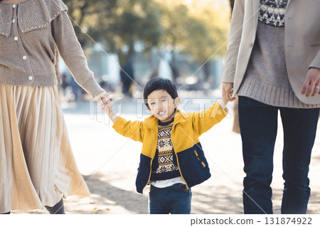 A close family walking hand in hand along a tree-lined path in an autumn park A close family walking hand in hand along a tree-lined path in an autumn park 131874922