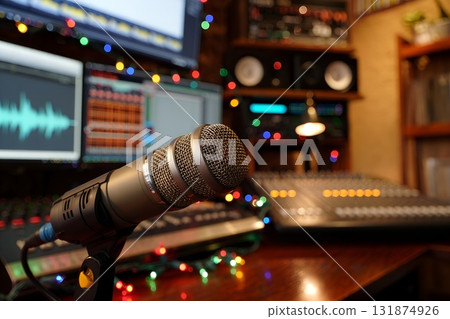 Close up view of a professional microphone in a recording studio, with festive colorful bokeh lights blurred in the background 131874926