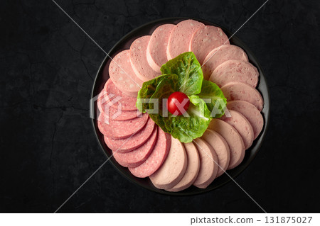 Various boiled sausages on a black background. 131875027