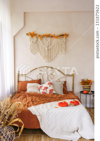 Cozy autumn bedroom interior with warm bedding, pillows, Halloween pumpkins and seasonal decoration Cozy autumn bedroom interior with warm bedding, pillows, Halloween pumpkins and seasonal decoration 131875622
