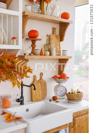 Autumn kitchen decor with pumpkins, cutting boards, and vibrant foliage in a bright space Autumn kitchen decor with pumpkins, cutting boards, and vibrant foliage in a bright space 131875631