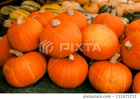 Fresh orange pumpkins stacked together at a market stall, symbolizing seasonal harvest, organic Fresh orange pumpkins stacked together at a market stall, symbolizing seasonal harvest, organic 131875731