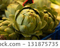 Fresh green artichoke photographed closeup at a market stall, symbolizing organic farming, healthy 131875735