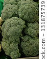 Fresh green broccoli heads piled together at a market stall, symbolizing organic farming, plant 131875739
