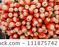 Bunch of fresh red and white radishes displayed at a market stall, showing vibrant colors, roots 131875742