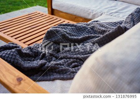 Wooden outdoor sofa with blanket on patio terrace 131876995