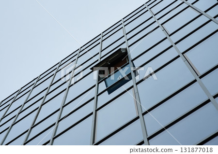 Glass facade of modern building with open window 131877018