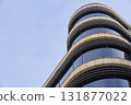Modern glass building with curved facade against blue sky 131877022