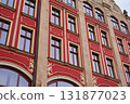 Historic building facade with ornate windows and decorative elements 131877023
