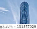 Modern glass skyscraper tower against blue sky 131877029