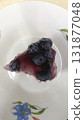 Blueberry topping cheesecake slice white plate with floral pattern, glossy fruit glaze and creamy texture, appetizing dessert presentation 131877048
