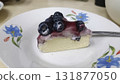 Blueberry cheesecake slice on floral plate with glossy berry topping and creamy filling, inviting dessert delight 131877050
