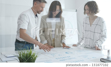 Professional team reviewing financial data, collaborating on working documents, demonstrating team achievements and positive dynamics in the workplace. Business people concept Professional team reviewing financial data, collaborating on working documents, demonstrating team achievements and positive dynamics in the workplace. Business people concept 131877102