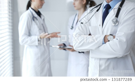 Medical team of doctors collaborating and consulting in a bright hospital setting, showcasing patient care, professionalism, and teamwork among healthcare workers Medical team of doctors collaborating and consulting in a bright hospital setting, showcasing patient care, professionalism, and teamwork among healthcare workers 131877289