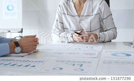 Business team meeting with financial documents and charts, discussing data analysis, planning strategies, and corporate success during collaborative teamwork session Business team meeting with financial documents and charts, discussing data analysis, planning strategies, and corporate success during collaborative teamwork session 131877290