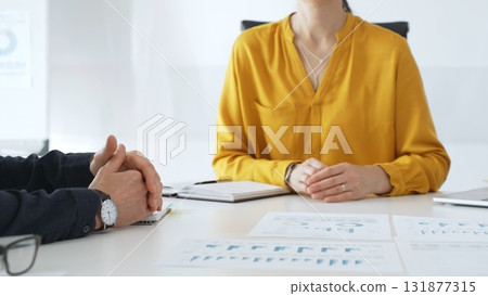 Business professionals discussing financial charts, collaborating on data analysis and strategic planning in contemporary workplace setting with graphs and reports 131877315