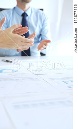 Diverse business people clapping hands in meeting celebrating success with financial charts, performance reports, teamwork, company growth, and management achievement 131877316