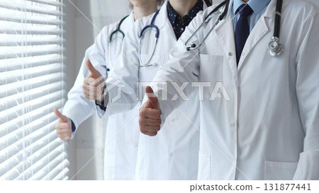 Medical team showing thumbs up gestures, symbolizing healthcare success, collaboration, good results, excellent medical service, and professional doctor approval 131877441