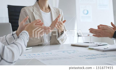 Professional business team clapping hands, celebrating successful presentation, displaying collaborative spirit and workplace enthusiasm in modern office setting Professional business team clapping hands, celebrating successful presentation, displaying collaborative spirit and workplace enthusiasm in modern office setting 131877455