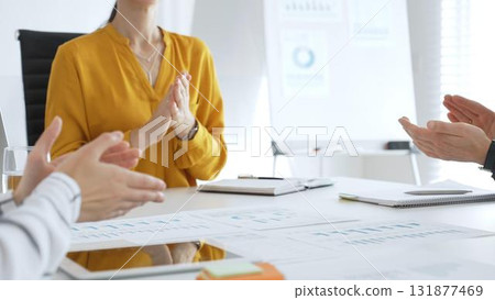 Business colleagues clapping hands after successful presentation or good news during a corporate meeting, celebrating achievement and success in office Business colleagues clapping hands after successful presentation or good news during a corporate meeting, celebrating achievement and success in office 131877469