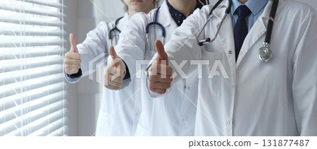 Medical team showing thumbs up gestures, symbolizing healthcare success, collaboration, good results, excellent medical service, and professional doctor approval 131877487