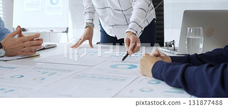Business team analyzing financial charts during strategy meeting, professionals discussing data and performance metrics at workplace for decision making success 131877488