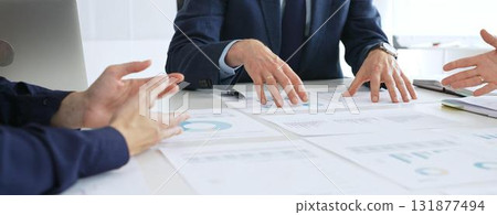 Business professionals discuss financial reports and marketing strategies during a corporate meeting, focusing on marketing, planning, data analysis, and teamwork 131877494