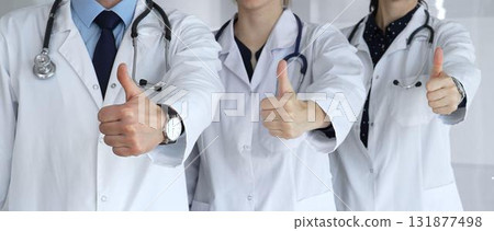 Doctor team showing thumbs up, symbolizing healthcare success, medical approval, achieving goals, quality patient care, positive health outcomes, and professional support 131877498