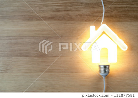 Light bulb with wood house model on a table. Top view with copy space for text. Creative home lights idea, power energy, property. Future smart technology innovation. Innovative real estate concepts 131877591
