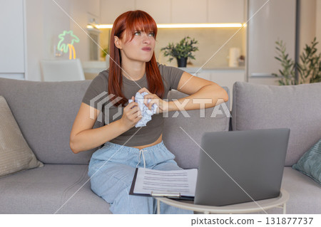 Young woman crumples wrong invoice tosses near laptop plans to print new corrected bill clean copy 131877737