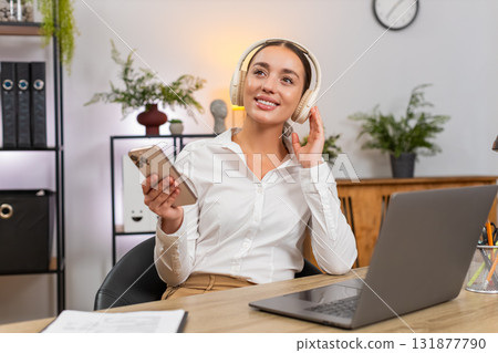 Young businesswoman plays soft music on smartphone relax chill taking a break and rests after work 131877790
