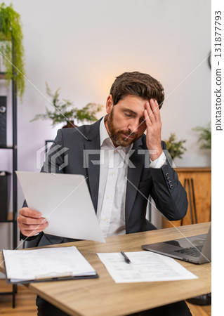 Middle-aged businessman lawyer reviews contracts finds mistake facepalm then corrects with pen fast Middle-aged businessman lawyer reviews contracts finds mistake facepalm then corrects with pen fast 131877793