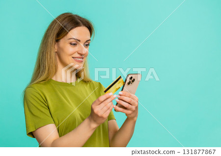 Woman holding smartphone credit card making online purchase clicking order with focused expression 131877867