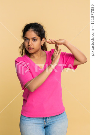 Indian woman forming timeout gesture with hands, looking seriously at camera requesting short break Indian woman forming timeout gesture with hands, looking seriously at camera requesting short break 131877889