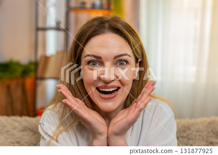 Adult woman looking at camera with surprise at home, wide eyes and wow expression showing excitement 131877925