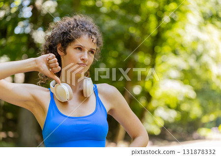 Upset sportswoman showing thumbs down dislike gesture expressing discontent disapproval dissatisfied Upset sportswoman showing thumbs down dislike gesture expressing discontent disapproval dissatisfied 131878332