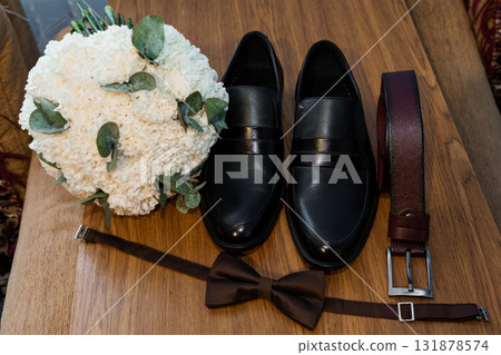 Elegant Wedding Details: Black Loafers, Brown Bowtie and Belt, White Bouquet - Groom Accessories, Rustic Wood Texture, Formal Style Elegant Wedding Details: Black Loafers, Brown Bowtie and Belt, White Bouquet - Groom Accessories, Rustic Wood Texture, Formal Style 131878574