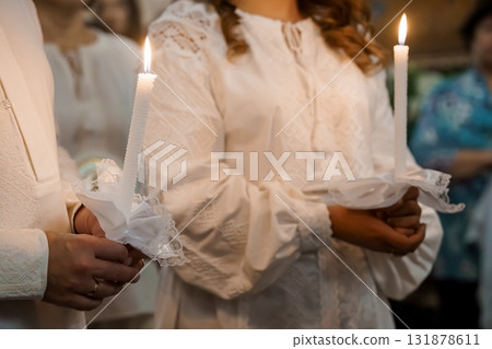 Orthodox Christian Wedding Ceremony Candles Lighted, Traditional White Garments, Religious Ritual, Warm Interior Lighting, Spiritual Scene 131878611