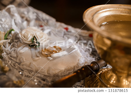 Orthodox Wedding Ceremony Rings and Holy Water on Embroidered Cloth, Golden Tones, Lace Texture, Religious Tradition, Still Life Photography 131878615