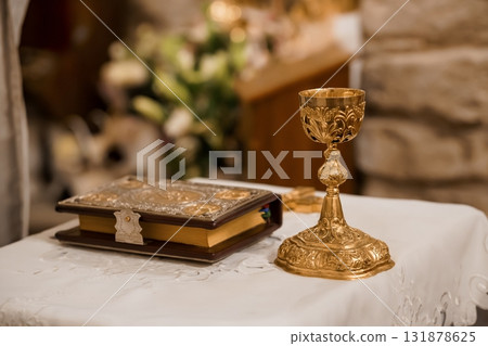 Golden Chalice and Sacred Text on Altar Cloth: Catholic Eucharist Ritual Symbolism, Religious Ceremony Still Life, Antique Gold, Vintage Style 131878625