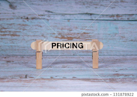 Pricing symbol. Single Wooden stick squeezed by Clothespins, Grungy blue Wooden Texture Background. Business and Pricing concept with copy space 131878922