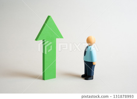 An office worker looks at a green growth arrow. Assess growth and success. Be a role model. Business success. Motivation, professional achievement, and goal setting. Personal development 131878993