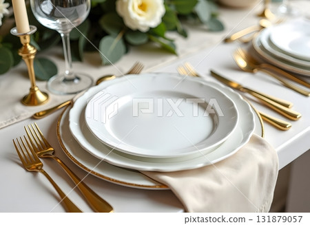Spring minimalist table setting in warm neutral colors. Easter festive table decoration, white plates, gold cutlery, candles, eggs and willow branches in vase 131879057