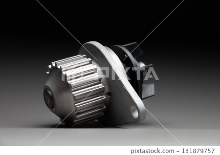 A new, shiny aluminum engine coolant pump on a gray gradient background. Contrast backlighting. A new, shiny aluminum engine coolant pump on a gray gradient background. Contrast backlighting. 131879757