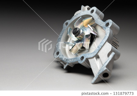 A water pump for a car's cooling system on a black gradient background. The water pump circulates coolant through the engine block. The car parts are new. 131879773