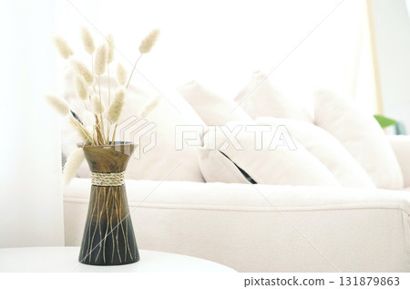 Soft grass feather flower In a wooden vase on the table in a bright living room with a white sofa set as the background and empty space for content Soft grass feather flower In a wooden vase on the table in a bright living room with a white sofa set as the background and empty space for content 131879863