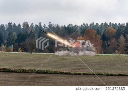 Launch of a missile from an anti-missile system against a backdrop of trees. Launch of a missile from an anti-missile system against a backdrop of trees. 131879885